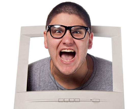 Mad nerdy guy sticking his head through a computer monitor