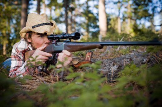 Prone positioned hunter taking aim