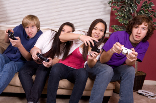 Teenagers sitting on a couch playing video games