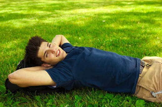 student laying in grass