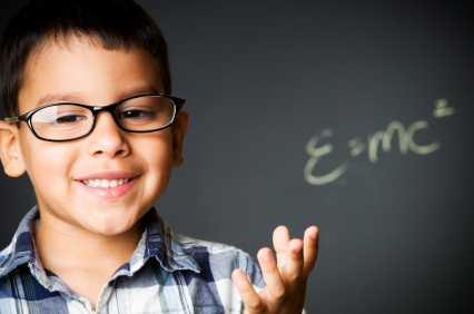 child wearing glasses in front of a chalkboard